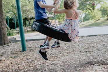 two children on a tire swing