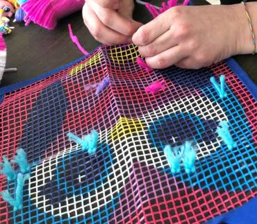 woman working on a latch hook kit as part of ABA therapy