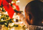 little boy decorating a Christmas tree