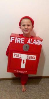 A young autistic boy wearing a Halloween costume of a fire alarm
