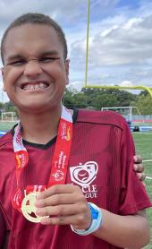 Klemente wearing a Special Olympics metal with a big smile